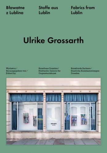 KI generiert: Das Bild zeigt das Cover eines Buches oder Katalogs mit dem Titel "Stoffe aus Lublin" von Ulrike Grossarth, herausgegeben vom Kunsthaus Dresden. Auf dem Cover ist ein Bild von Schaufenstern, hinter denen Stoffe präsentiert werden.