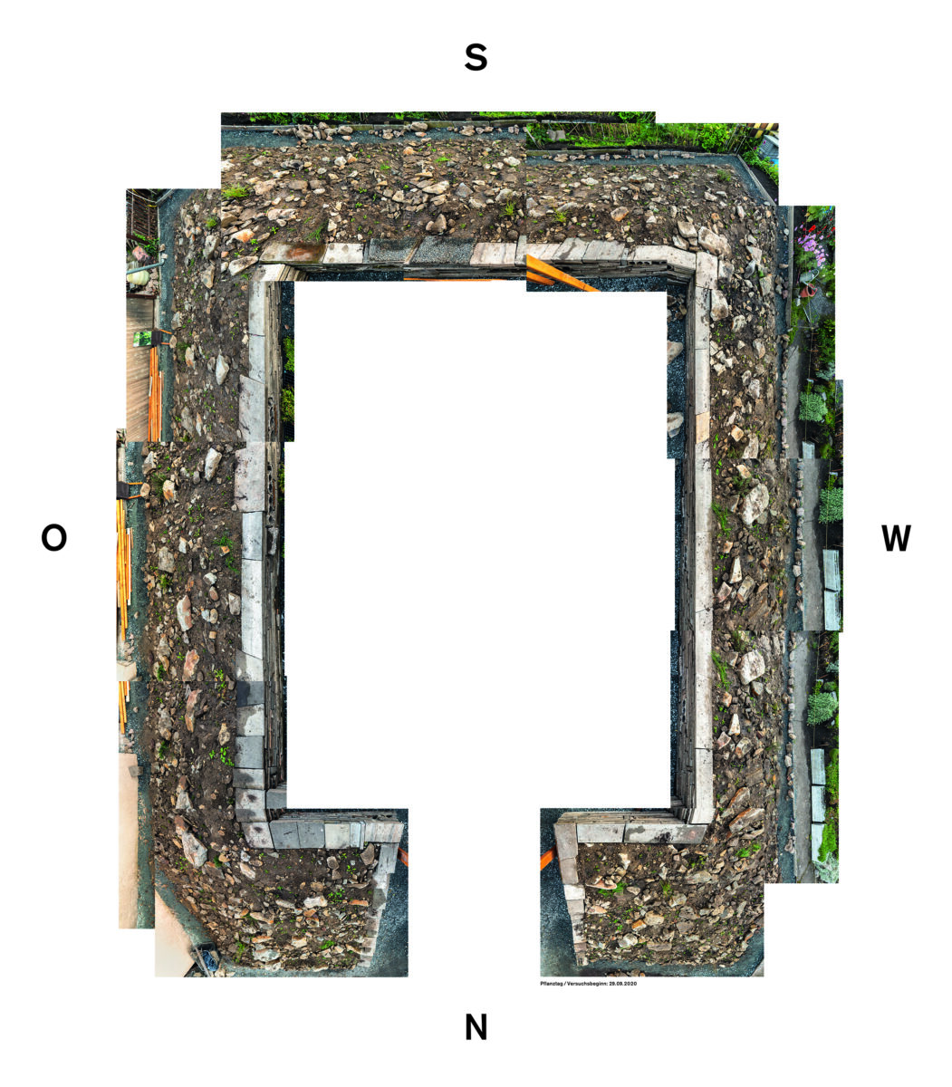 KI generiert: Das Bild zeigt eine Luftaufnahme einer rechteckigen Baugrube, umgeben von Erdreich und Bauschutt. Die Himmelsrichtungen sind markiert, um die Orientierung der Baustelle zu verdeutlichen.