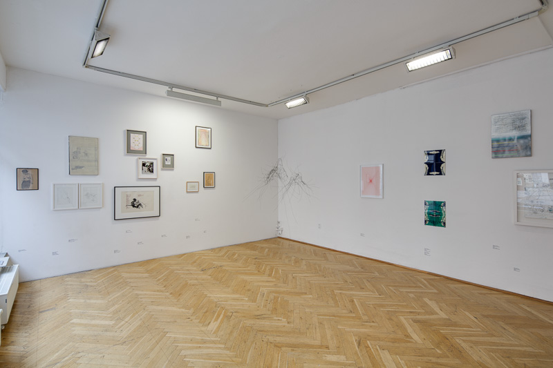 KI generiert: Das Bild zeigt einen minimalistisch eingerichteten Ausstellungsraum mit verschiedenen Kunstwerken, die an weißen Wänden hängen. Der Raum hat einen hölzernen Parkettboden und wird von Deckenleuchten beleuchtet.